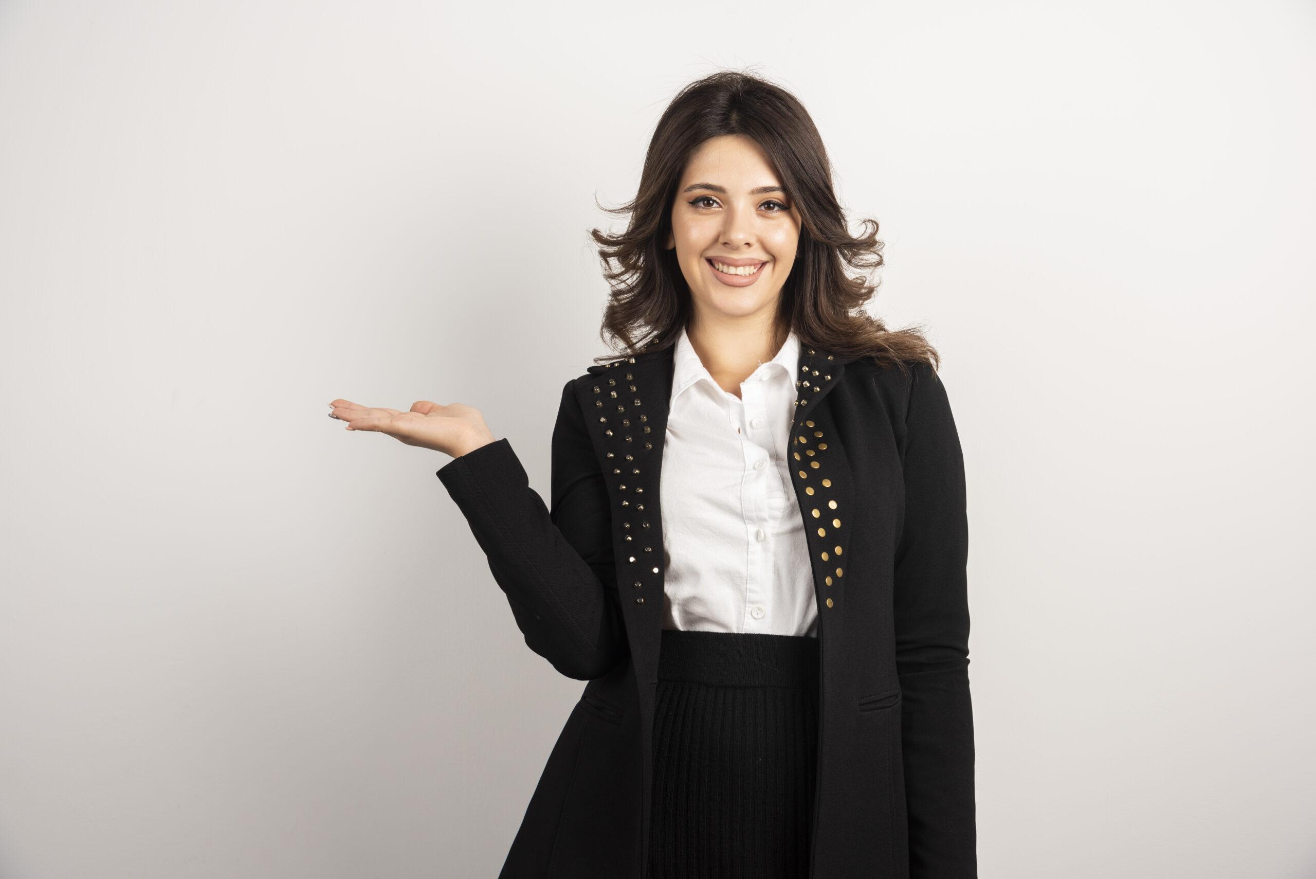 Portrait of young woman standing on white background